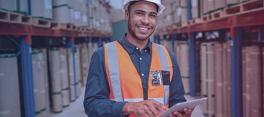 Life science factory manager using digital tablet in warehouse to manage manufacturing batch records.